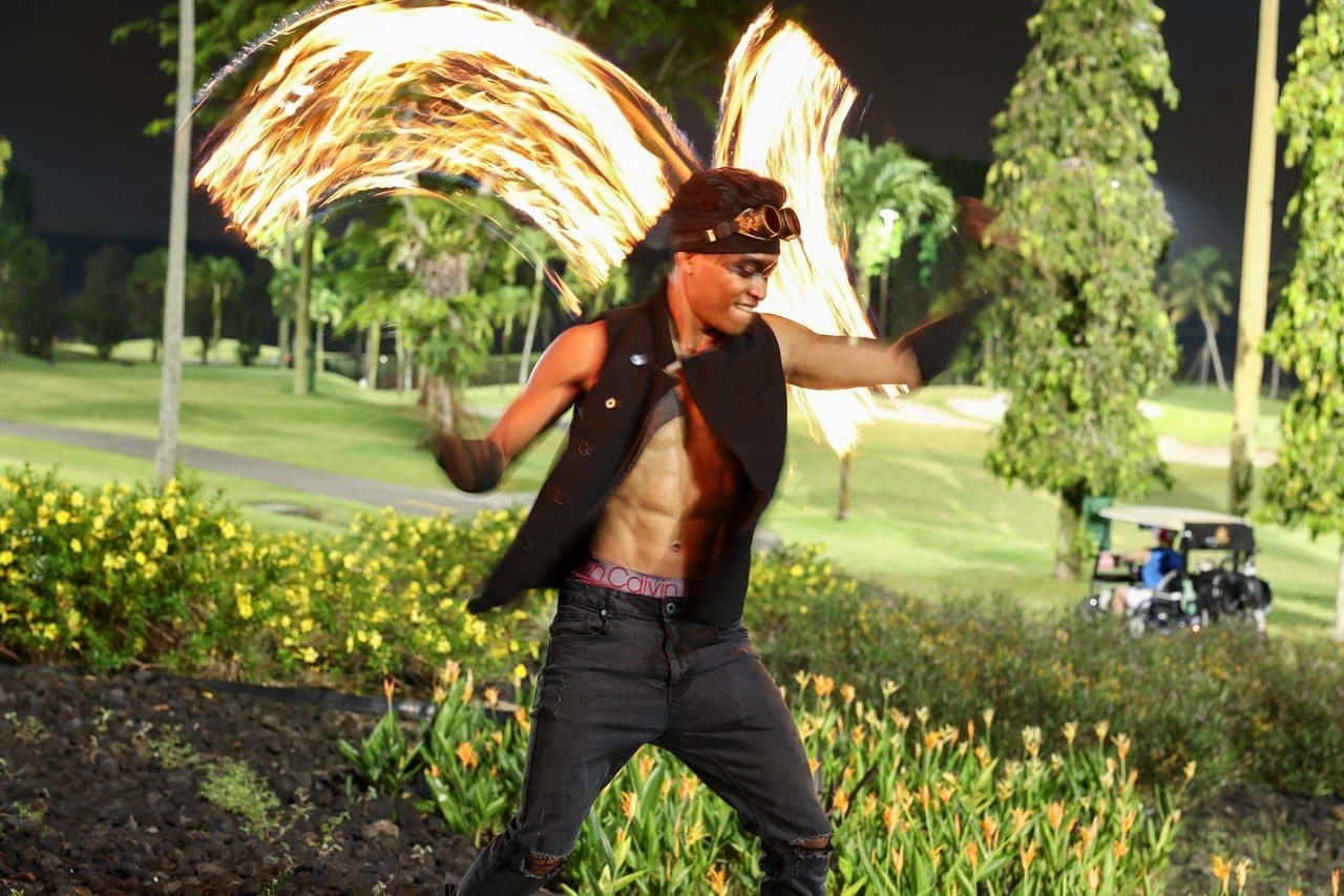 A fire performer at an evening event on the course